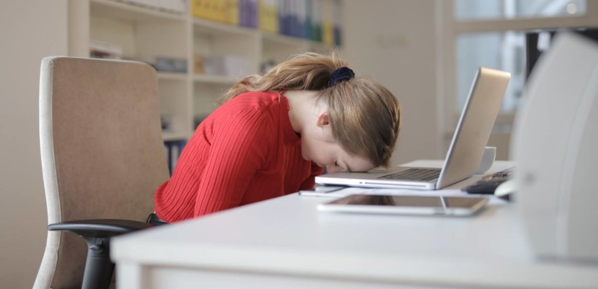 Woman asleep in front of computer in home office. Image credit: Andrea Piacquadio