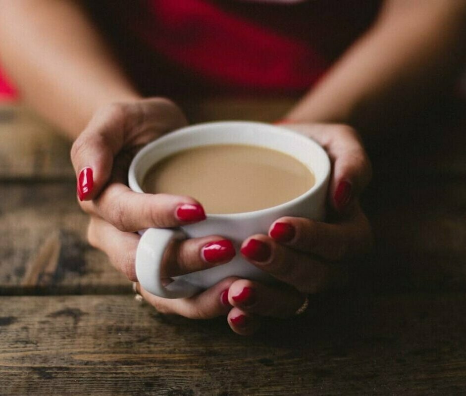 Woman holding a cup of coffee. Image credit Kristina Paukshtite