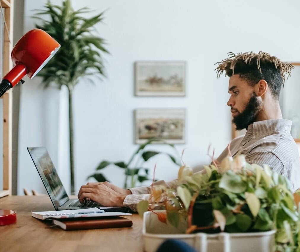 Man sitting at a table working on his computer. Image credit: Zen Chung