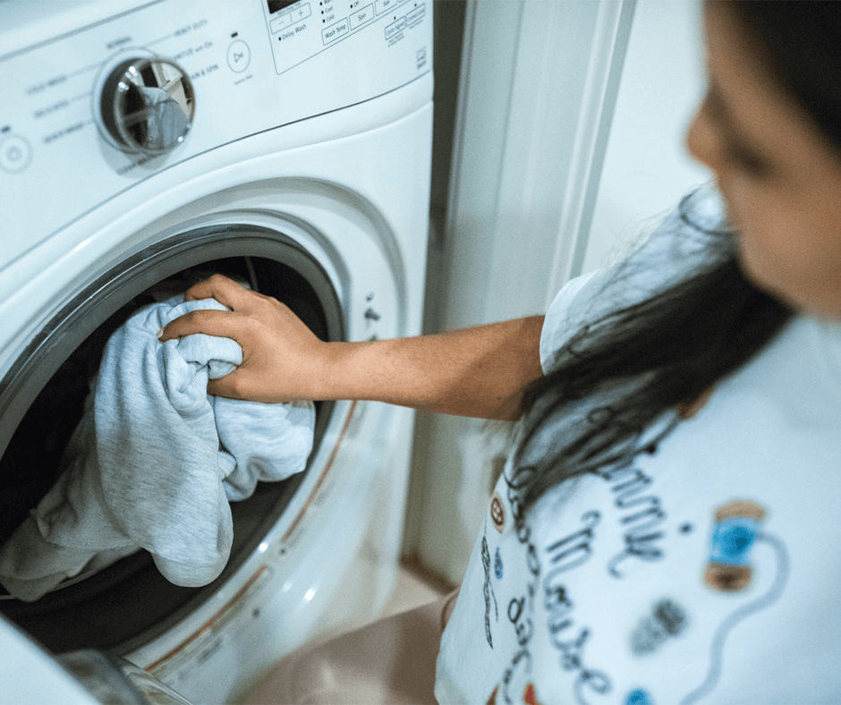 Women putting clothes into a dryer. Image credit: Rondae Productions