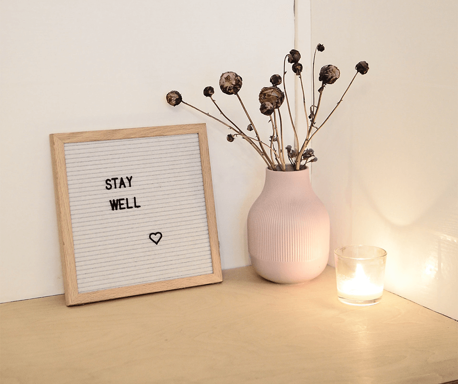 Decorative candle, vase, and small sign that says "stay well." Image credit: Skylar Kang