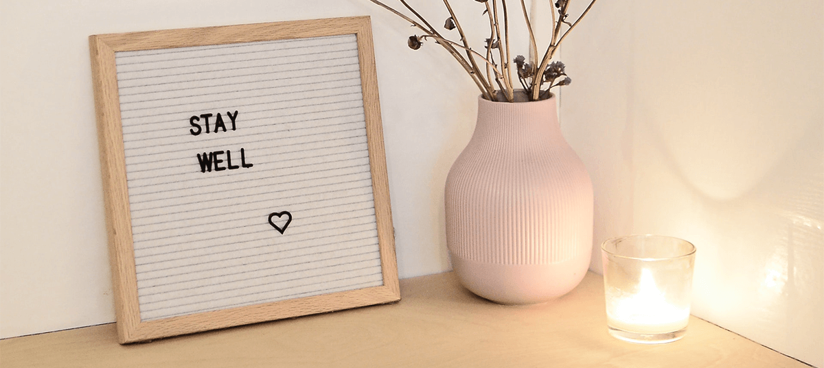 Decorative candle, vase, and small sign that says "stay well." Image credit: Skylar Kang