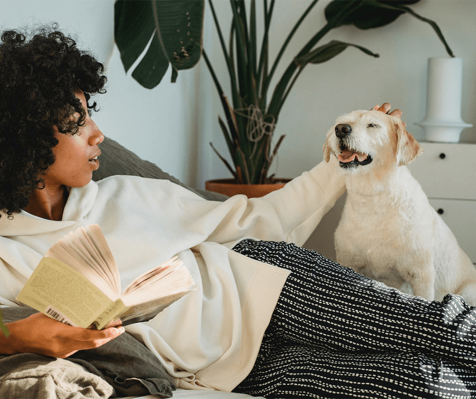 Dog watching a woman read a book. Image Credit: Samson Katt