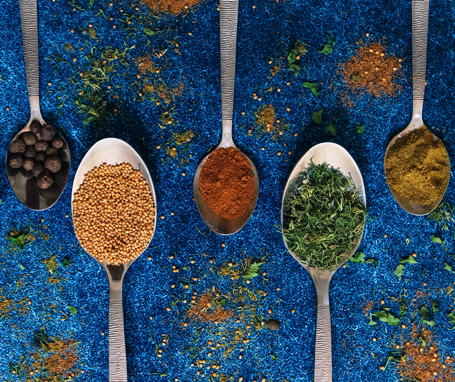Spoons holding various colorful spices. Image credit: Anastasia Belousova