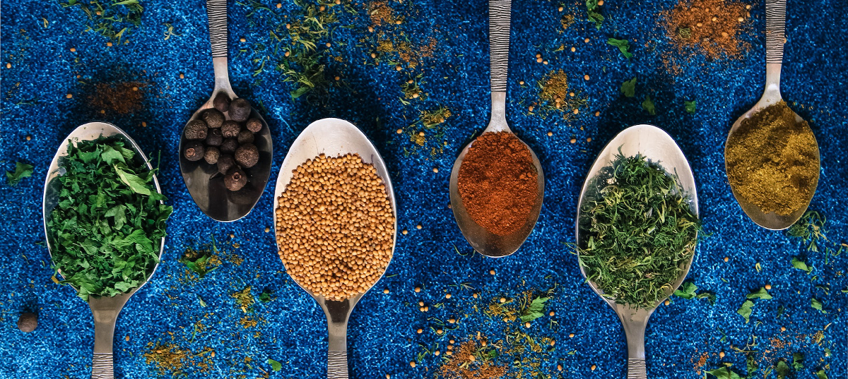 Spoons holding various colorful spices. Image credit: Anastasia Belousova