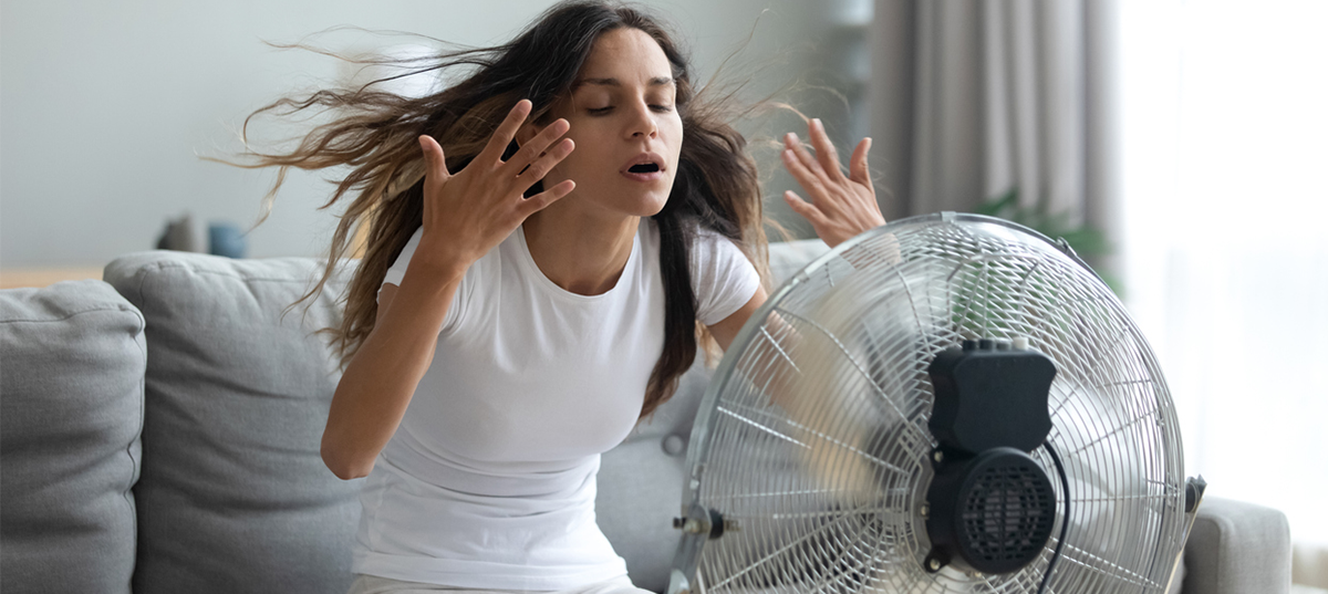 Woman cooling off with fan
