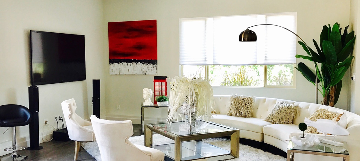 Photo of a living room with neutral colors and one bright red painting on the wall. Image credit: Level 23 Media.