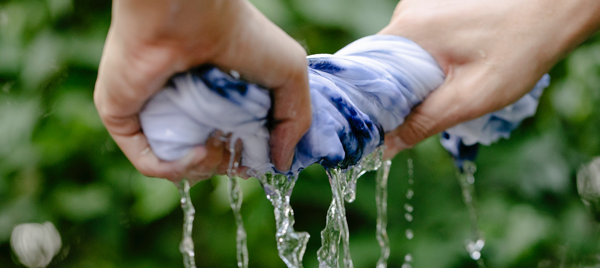 Woman wringing water from a wet t-shirt. Image credit: Tiona Swift