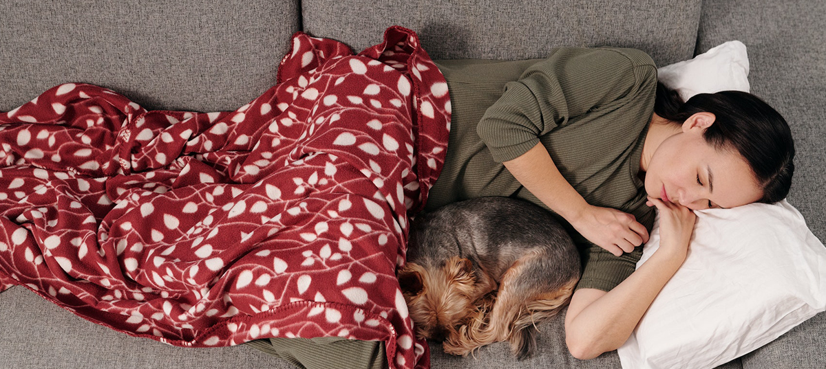 Woman napping on a sofa with her dog. Image credit: Jep Gambardella