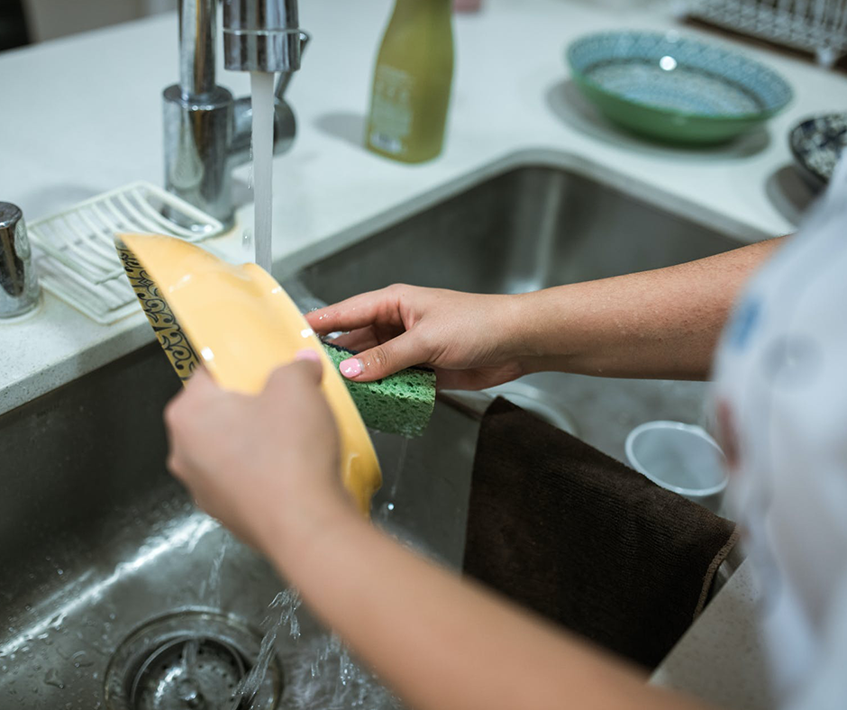 Woman washing a bowl with a sponge. Image credit RDNE Stock Project